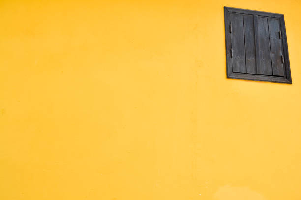 istock Yellow wall with wooden brown  window. Abstract composition 936952188