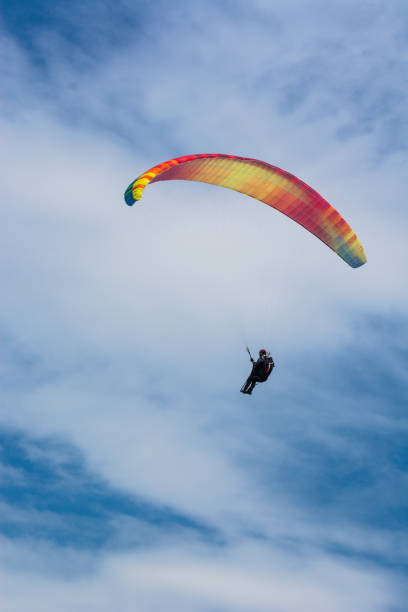 istock Paraglider flies in the blue summer sky 936953388