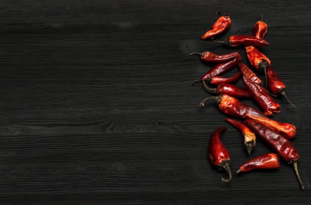 istock Dry Red chili pepper on black wooden surface background with copy space. 936955554