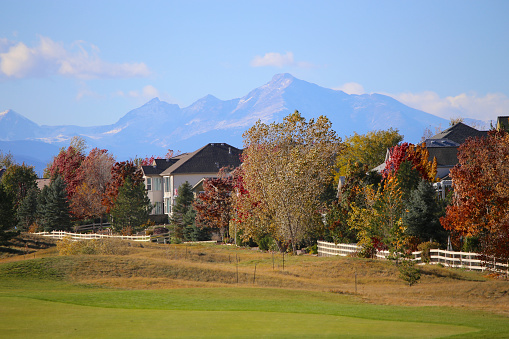 Rocky Mountains with fall colors are the backdrop for the residential golf course neighborhood of Broomfield, Colorado, a suburb of Denver.