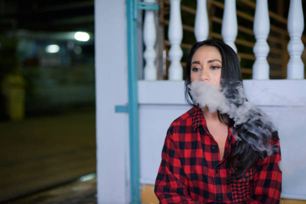 istock Young Woman Smoking Outdoors At Night 936963124