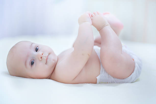 istock Happy kid wearing a diaper playing in a sunny bedroom 936966494