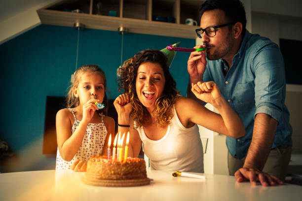 il compleanno della mamma. marito e figlia sorprendono madre e moglie con torta di compleanno. - birthday family party cake foto e immagini stock