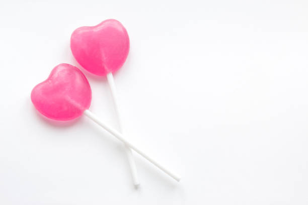 istock Two heart shaped lollipops on white background 936967124