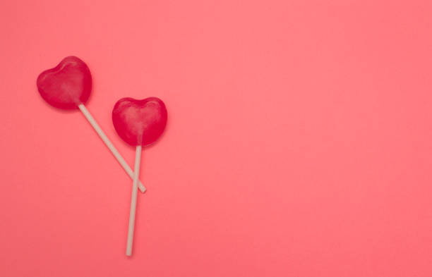 istock Two heart shaped lollipops on pink background 936967126