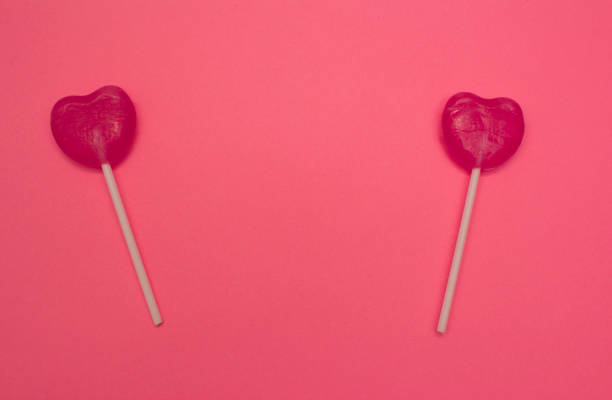 istock Two heart shaped lollipops on pink horizontal background 936967148