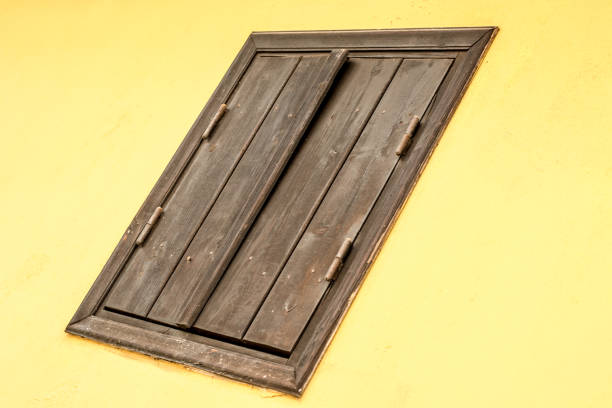 istock Yellow wall with wooden brown  window. Abstract composition 936967460
