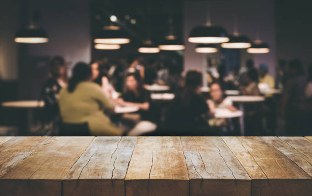 Wood table top (Bar) with blur people siting in cafe background Wood table top (Bar) with blur people siting in cafe background .Lifestyle and celebration concepts ideas food court photos stock pictures, royalty-free photos & images