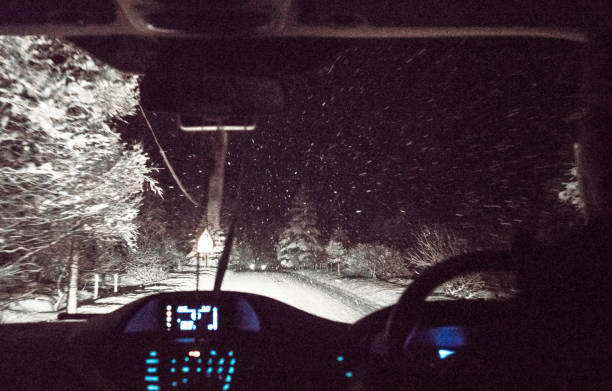 nachtfahrten im winterschnee - drivers point of view country road snowing blizzard stock-fotos und bilder