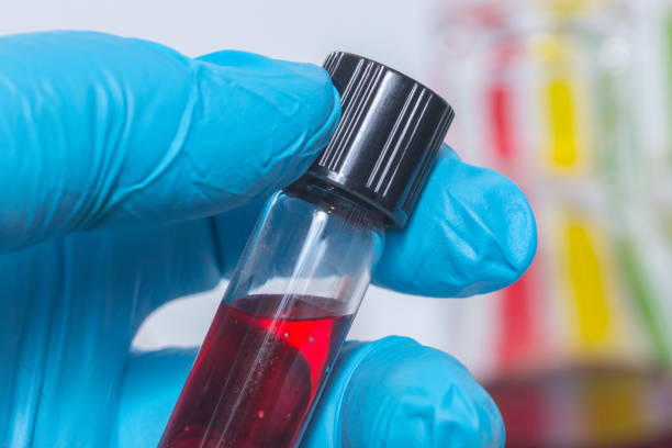 istock close up hand with glove holding red liquid 936973746