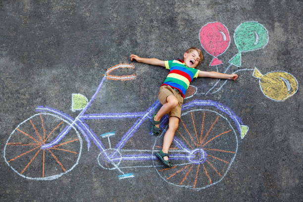 istock little kid boy having fun with bike chalks picture 936987180