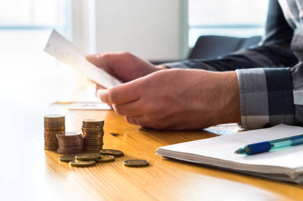 istock Man reading bank statement, check reminder, tax refund document, phone bill, or financial letter. Home or health insurance price and cost concept. 936987238