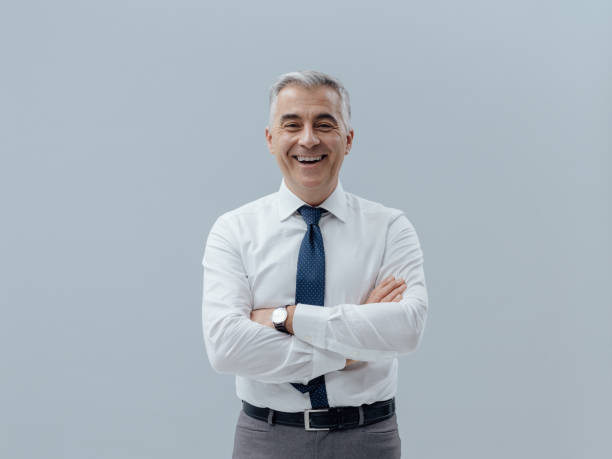 Smiling businessman with arms crossed stock photo