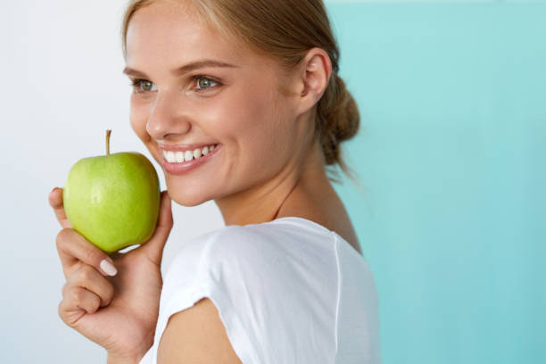 istock Smiling Woman With Beautiful Smile, White Teeth Holding Apple 936987834