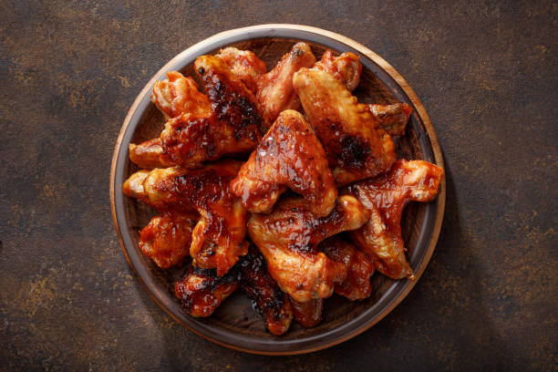 Barbecued chicken wings in the bbq sauce on the plate. stock photo