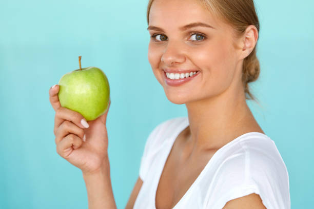 istock Smiling Woman With Beautiful Smile, White Teeth Holding Apple 936988032