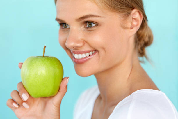 istock Smiling Woman With Beautiful Smile, White Teeth Holding Apple 936988198