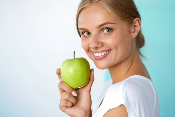 istock Smiling Woman With Beautiful Smile, White Teeth Holding Apple 936988340