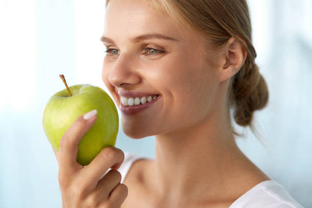 istock Woman Eating Apple. Beautiful Girl With White Teeth Biting Apple 936990640