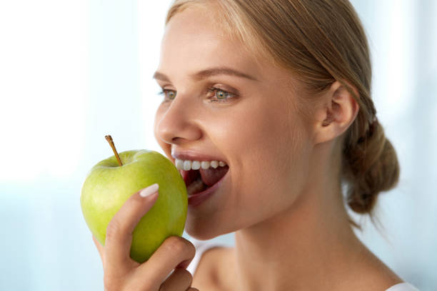 istock Woman Eating Apple. Beautiful Girl With White Teeth Biting Apple 936990892