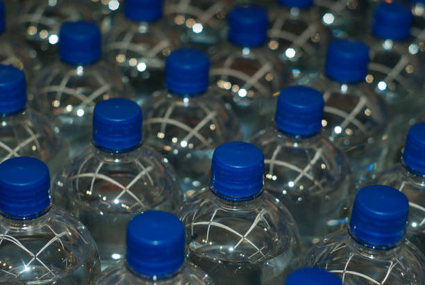 istock background - bottles with drinking water with blue stoppers 936992306