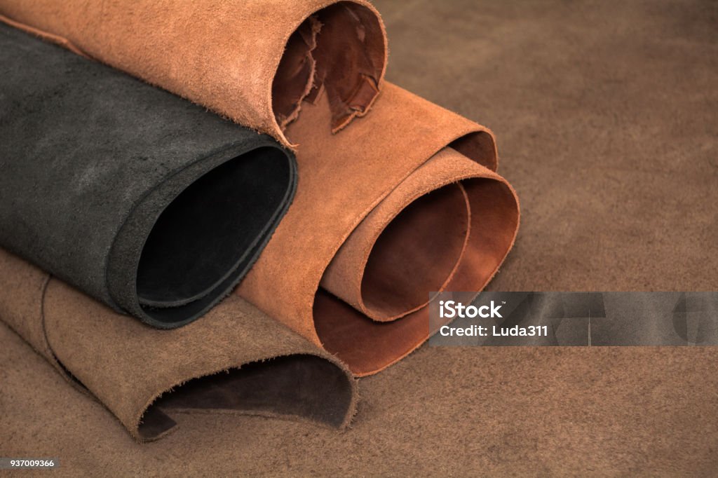 Rollos de cuero marrón y negro. Materiales para la artesanía de cuero - Foto de stock de Cuero libre de derechos