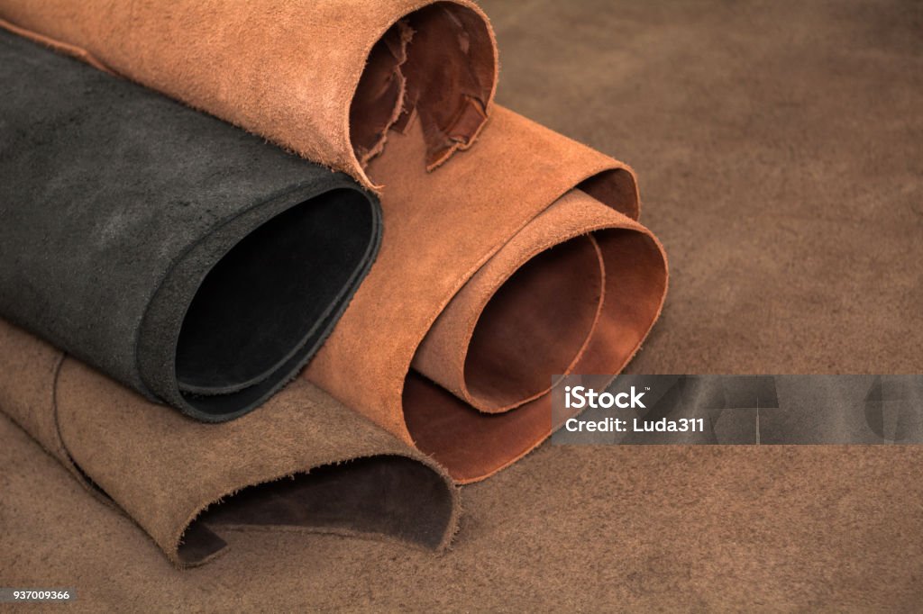 Rolls of natural brown and black leather. Materials for leather craft Rolls of natural brown and black leather. Materials for leather craft. Leather Stock Photo