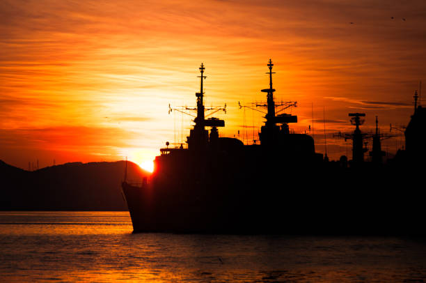 istock Military Navy Ships Silhouettes by Sunset 937009514
