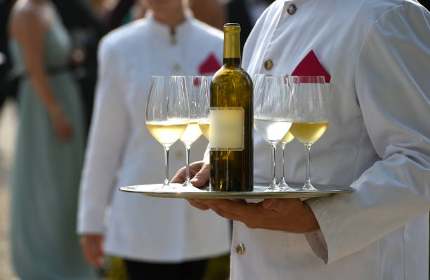 Waiters are serving vine at a wedding outdoor party, France