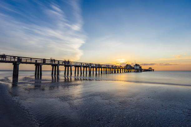 pôr do sol ao longo do cais de nápoles na flórida da praia - florida naples florida beach sunset - fotografias e filmes do acervo