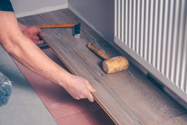 istock Working with hands installs a laminate board, professional flooring installation 937018580