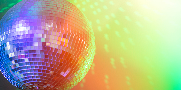 Disco ball in a nightclub with colorful lights.