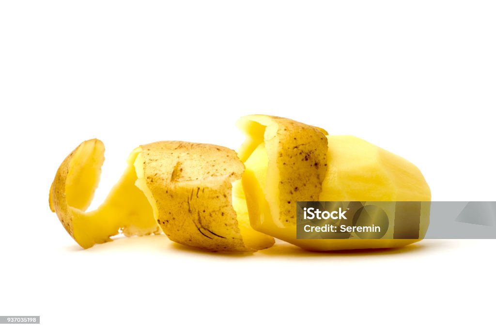 Peeled potatoes on a white background. Raw peeled potatoes and peelings close-up. Peeling Food Stock Photo