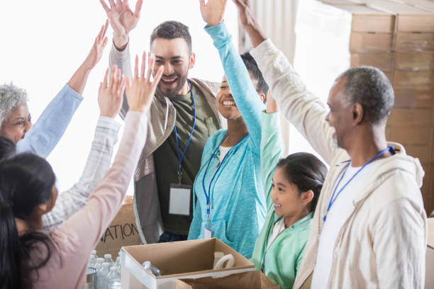 istock Group of volunteers cheer while working in food bank 937035366