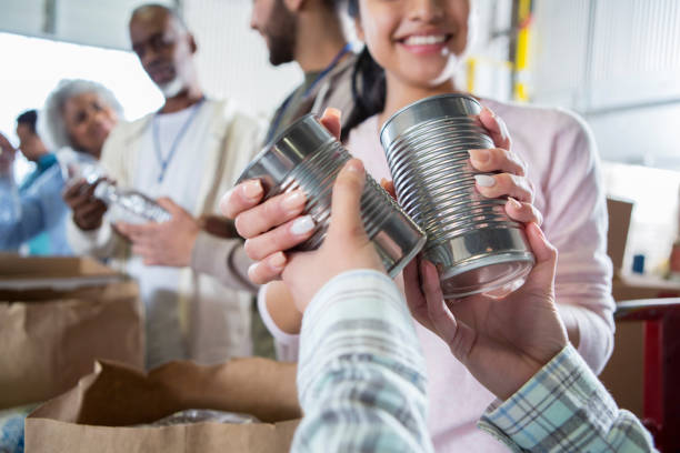 unrecognizable person donates food during food drive - food donation box groceries canned food imagens e fotografias de stock