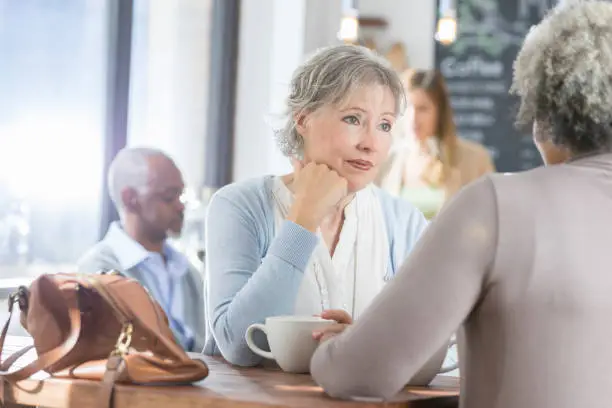 Photo of Empathetic woman attentively listens to her vulnerable friend