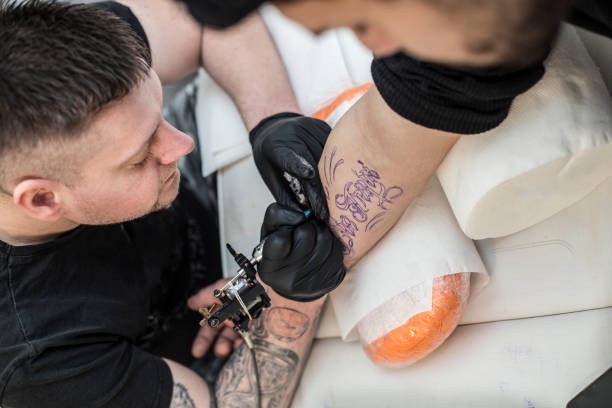istock Tattoo artist tattooing 937037576