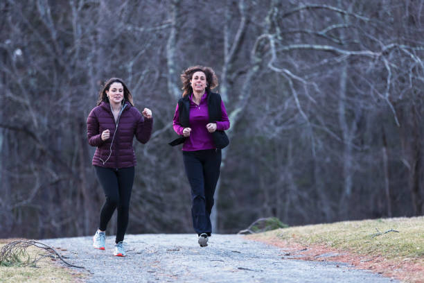 istock Mother and daughter jogging together for a workout 937038398