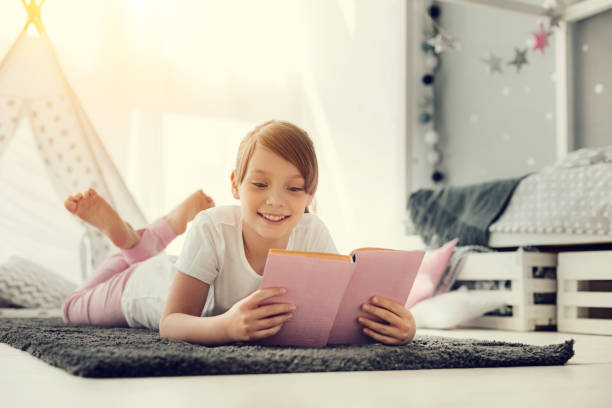istock Cheerful happy girl reading a book 937039014