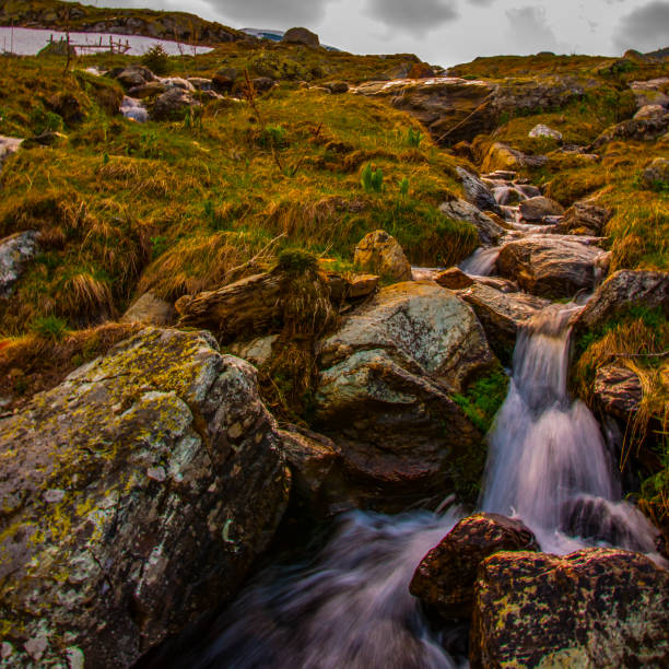 A high mountain waterfall makes its way through huge stones on a clear, summer day. High in the Caucasian mountains, in the outskirts of Dombai.chuhursky waterfall