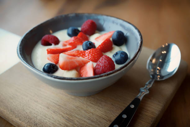 Cream and berries dessert in deep china plate, toned