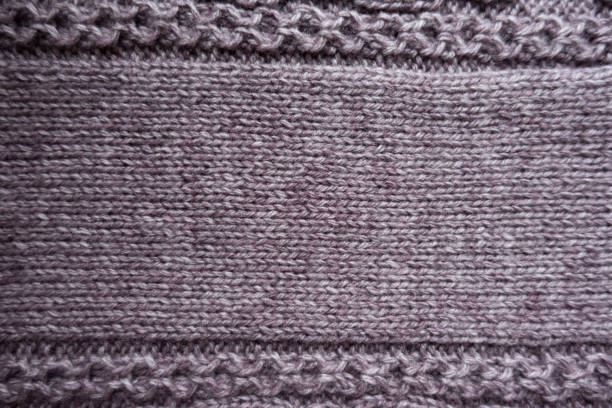 istock Relief ornamental pattern on edges of puce stocking stitch fabric 937049536