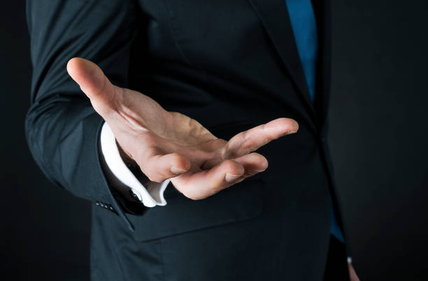 palma de la mano, hombre con un traje sostiene hacia fuera una mano vacía - turkish ethnicity white black contemporary fotografías e imágenes de stock