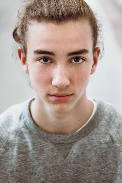 портрет красивого подростка с длинными волосами. старшеклассник - teenager adolescence portrait pensive стоковые фото и изображения