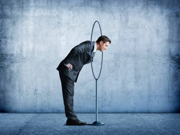 istock Businessman Puts His Head Through A Large Hoop On A Stand 937063632