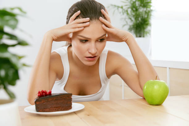 istock Diet And Nutrition. Woman Choosing Between Cake And Apple. 937063844