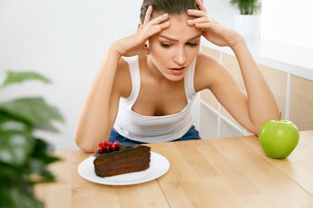 istock Diet And Nutrition. Woman Choosing Between Cake And Apple. 937063928