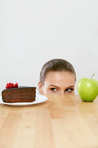 istock Diet And Nutrition. Woman Choosing Between Cake And Apple. 937063966