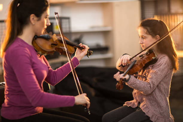 istock Music teacher instructing girl playing violin 937077792