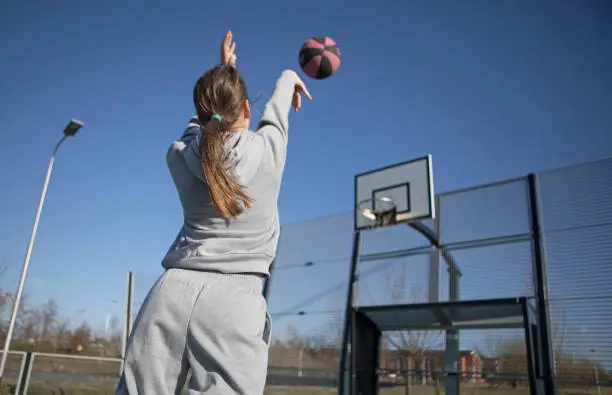 Outdoor urban basketball training session for individual female teenage girl streetball player